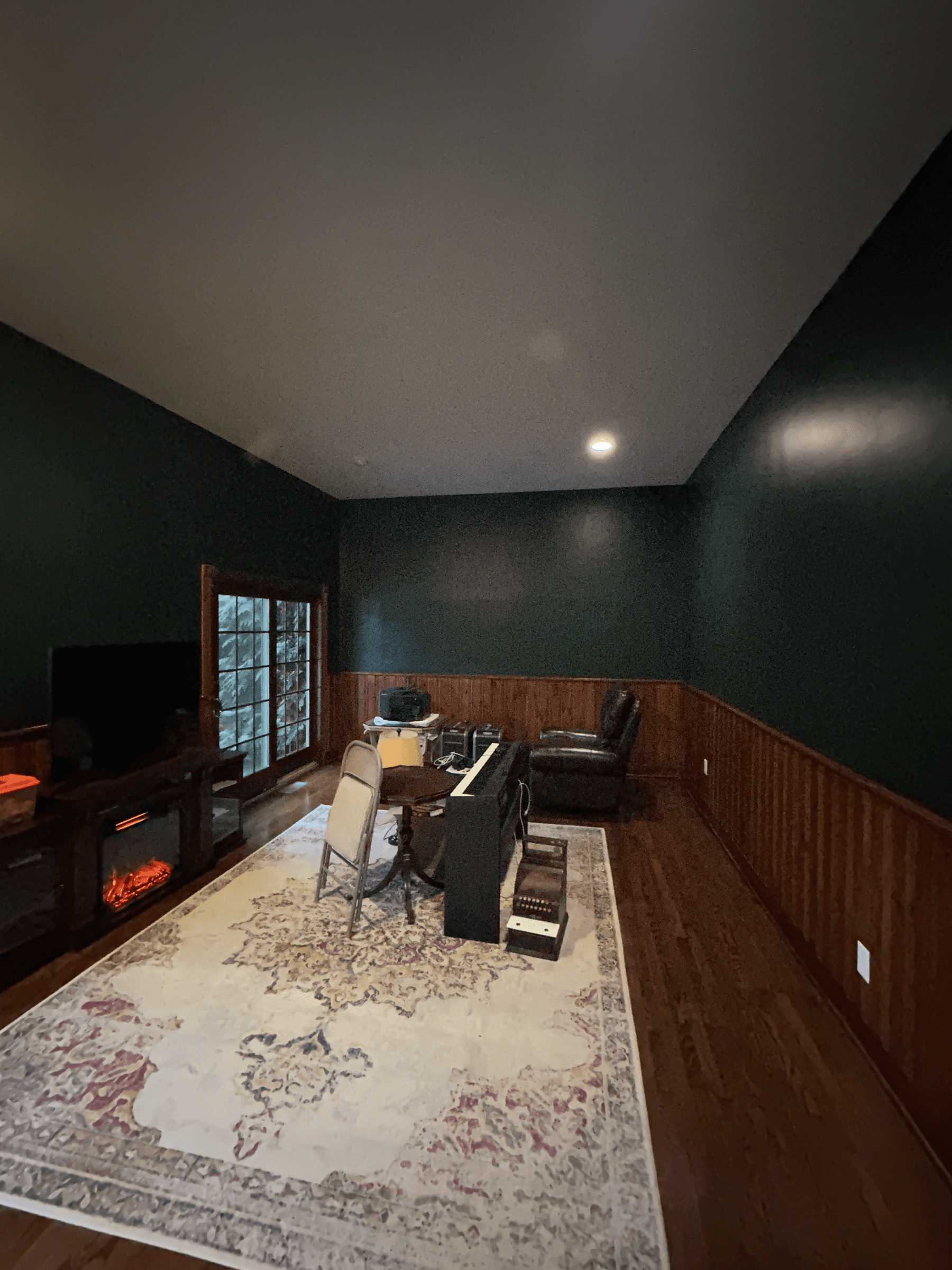 The same family room with the walls painted dark green, after painting