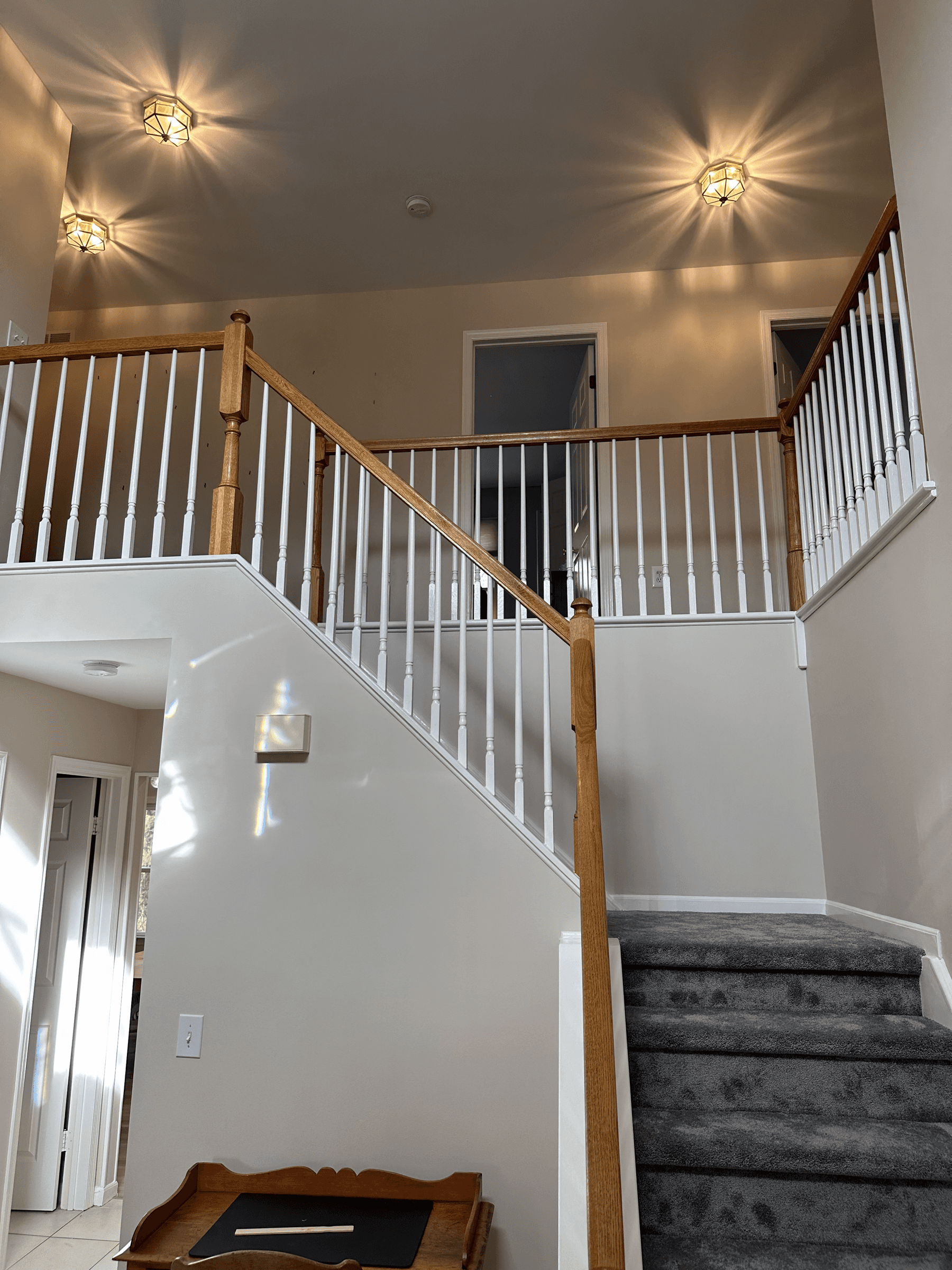 Two-story foyer with light walls and a staircase with white spindles